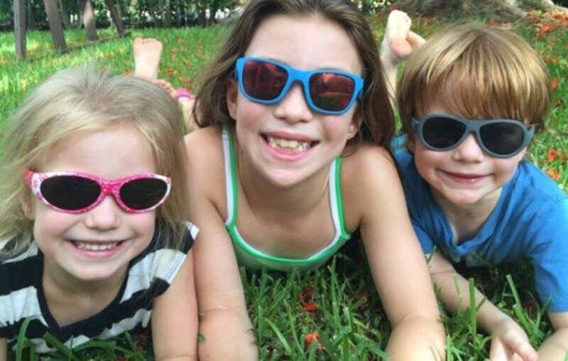 Children wearing kids' sunglasses on the grass